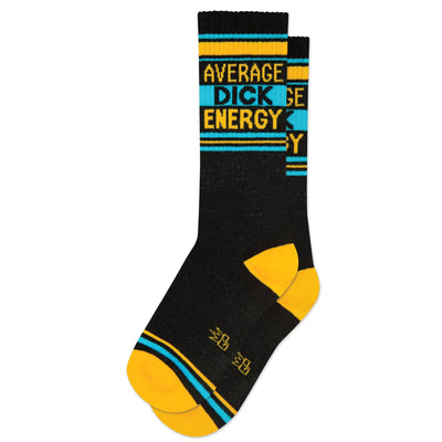 The Gumball Poodle Average Dick Energy Gym Crew Socks are black with yellow heels, toes, and stripes, plus blue and yellow accents and "AVERAGE DICK ENERGY" boldly printed near the top for extra swagger.