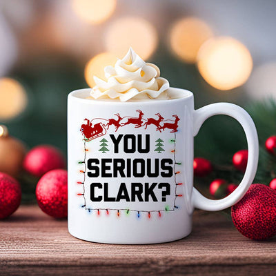 House Of Rodan’s “You Serious Clark - Christmas Vacation Coffee Mug” is an 11 oz, double-sided, dishwasher-safe mug showing “YOU SERIOUS CLARK?” with Santa’s sleigh, reindeer, and holiday lights—perfect for festive sipping.