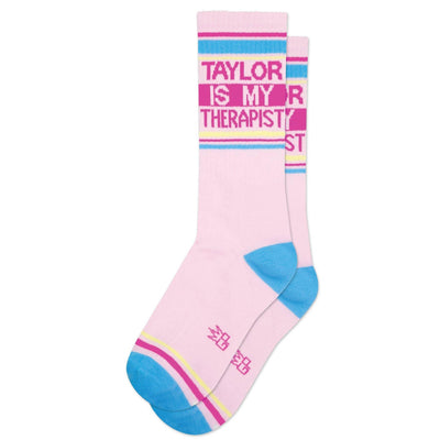 Gumball Poodle’s Taylor Is My Therapist Gym Crew Socks feature comfy pink fabric, blue toes and heels, bold text near the top, plus pink and yellow stripes by the toes—perfect for any Taylor fan!.