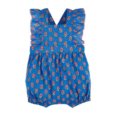 Mud Pies Blue Block Print Romper is a charming cotton voile piece with flutter sleeves, crossing back straps, and a red and white floral pattern on a blue backdrop. The sleeveless design features ruffled shoulders and a gathered hem for an adorable touch.