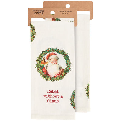 The Rebel Without a Claus Kitchen Towel by Primitives by Kathy features Santa inside a holly wreath and the phrase Rebel without a Claus. Set includes two white cotton towels on cardboard hangers, sized for generous daily use.