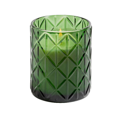 The 15oz. Cedar & Pine Candle by Hillhouse Naturals/Field+Fleur is presented in a green, diamond-patterned glass holder, shown on a white background.