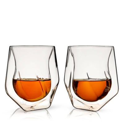Two Alchemi™ Double Walled Aerating Tasting Glasses by Viski, made of borosilicate glass, sit side by side on a white surface, each filled with amber liquid. Set of 2.