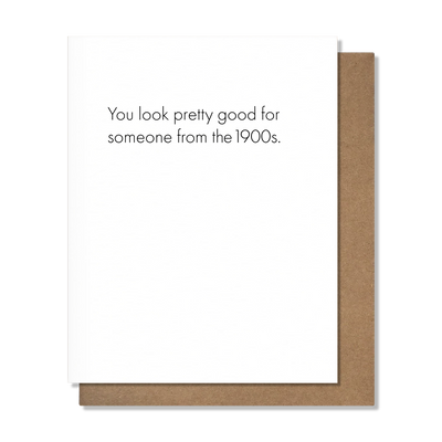 The 1900's - Birthday Card by Pretty Alright Goods features the text "You look pretty good for someone from the 1900s." and is shown atop a brown envelope on a light gray background.