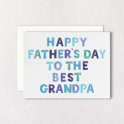 The Gert & Co Best Grandpa Fathers Day Greeting Card features blue and purple text on a light textured background, comes with a white envelope, and is printed on recycled paper by a woman-owned company.