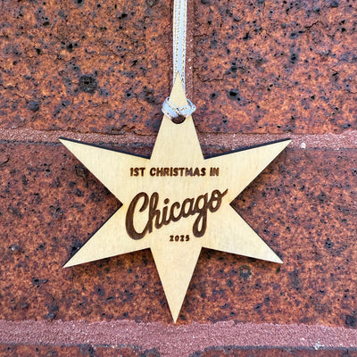 Star-shaped ornament with '1st Christmas in Chicago 2023' text on a textured brown background