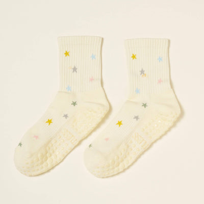 Effortless Club’s Star Grip Sock: cream-colored organic cotton with ribbed texture, multicolored star patterns, cushioned footbed, and non-slip soles—ideal Pilates socks shown on a light background.