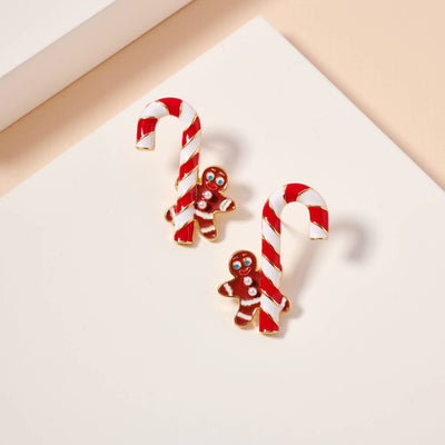 Frem's Candy Cane & Gingerbread Man Enamel Stud Earrings feature red and white candy canes adorned with gingerbread men, displayed on a pale, neutral background.