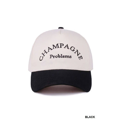 The 42POPS Champagne Problems Two Tone Baseball Cap - Black features a white crown, black brim, “CHAMPAGNE Problems” embroidered in black on the front, an adjustable strap, and “BLACK” in small text at the bottom right corner.