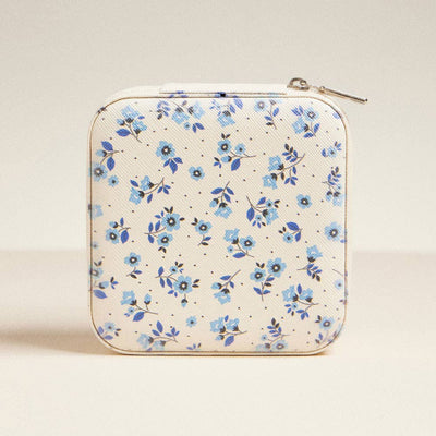 The Frem Blue Flower Pattern Jewelry Box is a square, cream-colored case with a zipper, featuring small blue flowers and green leaves. It stands upright against a light neutral background.