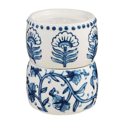 The Block Print Salt & Pepper Set by Mud Pie features two stacked ceramic cups with blue floral patterns on a white background; the top has a hand-painted rim and circular dots, and both showcase intricate flowers and vines.