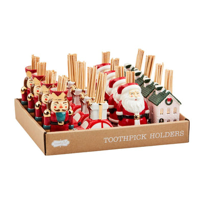 Mud Pie’s Winter Wonderland Toothpick Caddy Sets include festive, hand-painted ceramic holders shaped like nutcrackers, Santa Claus, gifts, and snowy houses—each charming caddy comes filled with toothpicks.