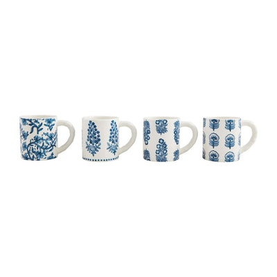 The Block Print Mugs by Mud Pie feature four white ceramic mugs with blue floral and botanical patterns, reminiscent of hand-stamped artistry. Each stoneware mug has a unique design in a classic blue and white color scheme, arranged from left to right on a pristine white background.