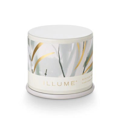 The Illume Candles Winter White Demi Tin Candle features a white lid, soft abstract design in pale green, gray, and gold, and a label highlighting plant-based wax and a frosted cypress aroma.