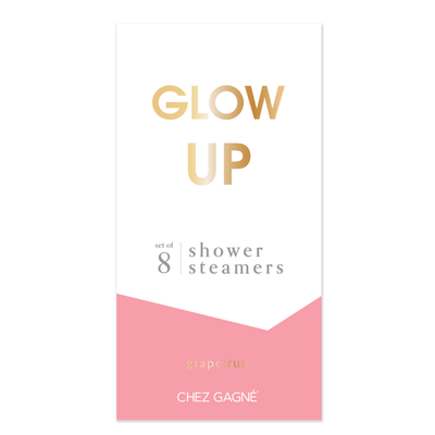 A white and pink rectangular box labeled GLOW UP in gold holds 8 Grapefruit-scented Aromatherapy Shower Steamers. The brand, Chez Gagné, appears at the bottom.