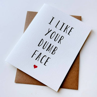 The Steel Petal Press Like Your Dumb Face card features bold black text with a small red heart printed in Pantone-matched ink on recycled cotton rag paper, and comes with a brown envelope.