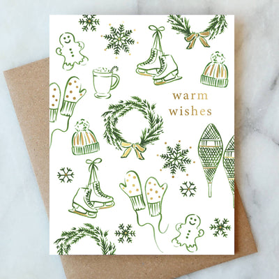 The Snowflakes and Skates Holiday Greeting Card Box Set of 6 by Abigail Jayne Design features sketched winter accessories and gold “Warm wishes.” Includes recycled kraft envelopes. A cheerful holiday greeting set!.