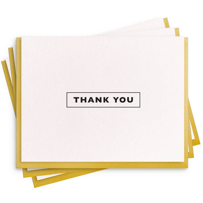 The Dahlia Press Thank You Box includes 6 elegant white letterpress thank you cards with gold edges and bold black THANK YOU text, blank inside for your message.