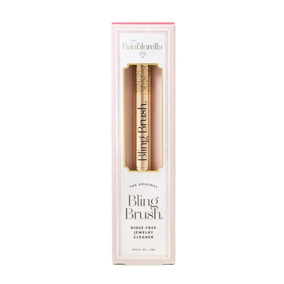 The gold Bling Brush Jewelry Cleaner by Baublerella is displayed in pink and white packaging with text: Baublerella, The Original Bling Brush, Rinse-Free Jewelry Cleaner. Ideal for making diamond rings shine using its non-toxic formula.