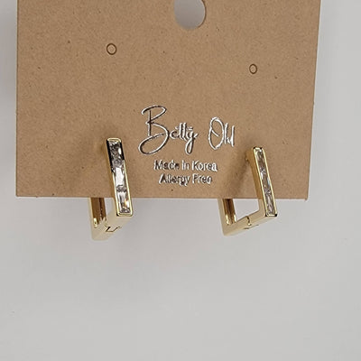 A pair of Square Huggie Hoops by BETTYOH INC, gold plated with cubic zirconia, displayed on a brown card labeled Betty Ou, Made in Korea, Allergy Free.