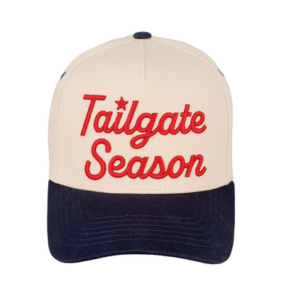 The Tailgate Season Embroidered Two Tone Baseball Cap by Judson & Company features beige and navy panels, red script embroidery, 100% cotton fabric, and a snap back closure. One size fits most for comfort and style.