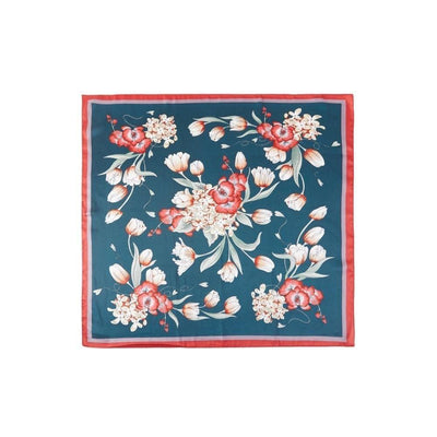 The Dora Lightweight Bandana Scarf by Judson & Company features a dark teal silk square with red, white, and pink floral patterns, a red border, and symmetric flowers—ideal as a chic bandana or classic scarf.