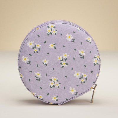 The Judson & Company Flowers & Leaves Travel Jewelry Box is a round, lavender accessory with a white and yellow daisy pattern, zipper closure, and ring slots—perfect as a coin purse or for organizing jewelry essentials.