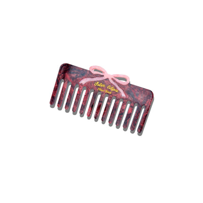 The Solar Eclipse Hand-Painted Vintage Bow Detangling Wide Tooth Hair Comb features a marbled purple and pink cellulose acetate body, a pink bow accent, and yellow Salon Culture text, displayed on a white background.