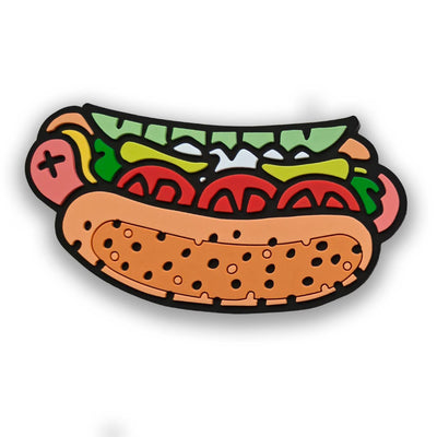 A playful Transit Tees Chicago Style Hot Dog PVC Magnet featuring a cartoon hot dog with tomato, lettuce, pickles, onions, and veggies in a bun on a white background—perfect for adding Chicago flair to any space.