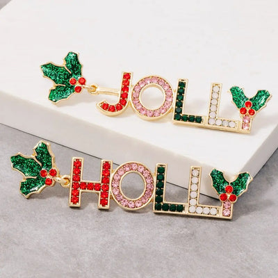 The Golden Stella Holly Jolly Dangle Earrings feature festive "JOLLY" and "HOLLY" designs in gold with colorful rhinestones and holly leaves. Lead and nickel compliant, these cheerful studs brighten up any holiday look.