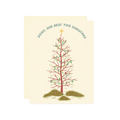 A funny Wallflower Paper & Party card shows a sparse Christmas tree with a star, scattered needles, and the text "DOING OUR BEST THIS CHRISTMAS." Do holidays your way with this BOXED SET OF 8 "Doing Our Best Christmas Card.