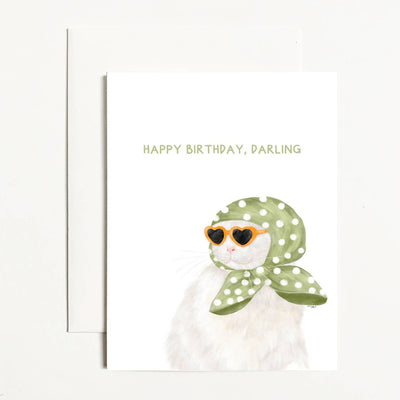 The Happy Birthday, Darling Cat Greeting Card by k.Patricia Designs features a white cat in heart sunglasses and a green polka dot scarf with “HAPPY BIRTHDAY, DARLING” in green. Blank inside; envelope included.