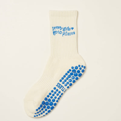 The Effortless Club Pilates Girl Grip Sock (French Blue) is a single white organic cotton sock with blue non-slip grip dots and pretty girls go to pilates written in blue on the side.
