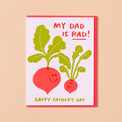 The Rad Dad Letterpress Radish Fathers Day Card by And Here We Are features two smiling radishes with green leaves on a soft beige background, MY DAD IS RAD! at the top, and HAPPY FATHERS DAY at the bottom.