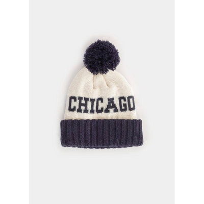 Stay warm in style with the Alice & Wonder Youth Mad Hatter Two-Tone Chicago Pom Beanie in navy, featuring a ribbed cuff and bold "CHICAGO" text on a cream background topped with a navy pom-pom.