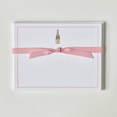 The Pink Champagne flat note cards from Georgetown Paperie feature a minimalist design on ultra-white paper with a champagne bottle illustration at the top. They come wrapped in a pink ribbon bow, perfect for pairing with elegant envelopes.