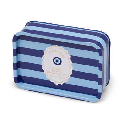 A rectangular tin candle with horizontal light and dark blue stripes, labeled “Paddywax Eye Dopo Printed Tin” in the center—a stylish pick for fans of bold fragrances and statement scented candles.