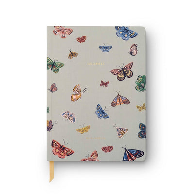 The Curio Butterfly Softcover Journal by Rifle Paper Co. features a light gray cover adorned with colorful butterfly illustrations and the word JOURNAL embossed in gold. It includes lined pages and a yellow grosgrain ribbon bookmark.