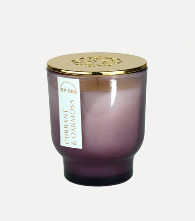 The Elum Currant & Oakmoss 7 oz Maeve Glass Candle features soy wax in a gradient purple jar with a gold lid embossed with an exquisite pattern. Labeled No 004, it embodies Aura Pure technology for tranquility.