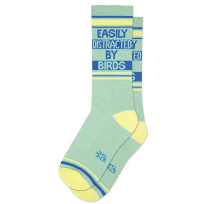 Gumball Poodles Easily Distracted by Birds Unisex Socks feature pastel green, mid-calf design with yellow accents, playful blue/yellow stripes, and “EASILY DISTRACTED BY BIRDS” text in blue for a fun style.