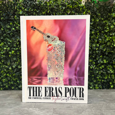 The Eras Pour by Penguin Random House LLC features a sparkling cocktail with a guitar-shaped stirrer on the cover, set against a pink and purple background—perfect for discovering Swiftie-inspired cocktail recipes.