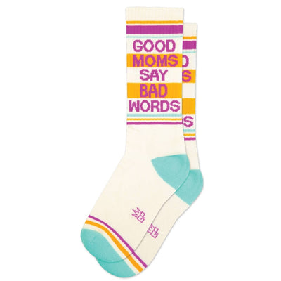 The Gumball Poodle Good Moms Say Bad Words Gym Crew Socks are unisex cotton socks in cream with teal toes and yellow, pink, and purple stripes. GOOD MOMS SAY BAD WORDS is boldly printed in colorful letters.