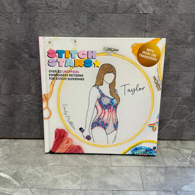 Stitch Stars: Taylor by Ingram Publishing is an embroidery book featuring an illustrated woman in a colorful swimsuit and embroidery tools on the cover. It offers over 40 unofficial patterns, including Taylor Swift outfit designs.