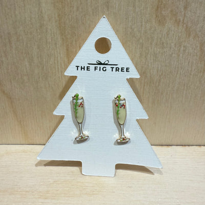 The Christmas Bubbly Enamel Stud Earrings by Prep Obsessed Wholesale feature festive champagne glasses with holly accents, displayed on a white card labeled THE FIG TREE—perfect for anyone who loves Christmas earrings.