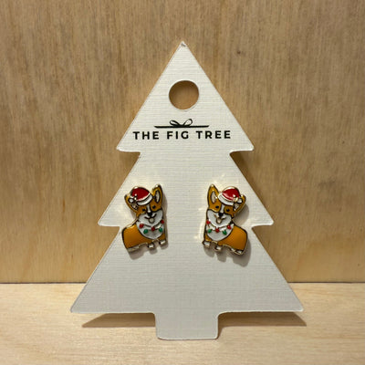 A pair of Prep Obsessed Wholesale's Christmas Lights Corgi Signature Enamel Stud Earrings is displayed on a Christmas tree-shaped card labeled "The Fig Tree" against a wooden background.