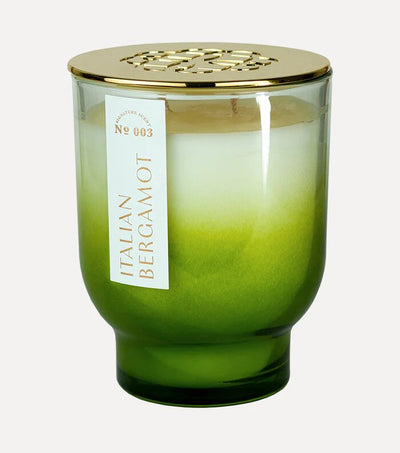 A 21 oz green gradient soy wax candle by Elum, named Italian Bergamot, in a glass jar with Aura Pure technology and an ornate gold lid.