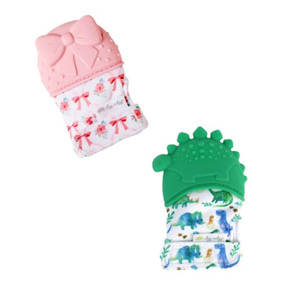 The Itzy Ritzy Itzy Mitt™ Silicone Teething Mitts include one pink glove with a bow and floral pattern, and one green glove with a dinosaur design. Each features colorful prints and a safe silicone teether to soothe sore gums.