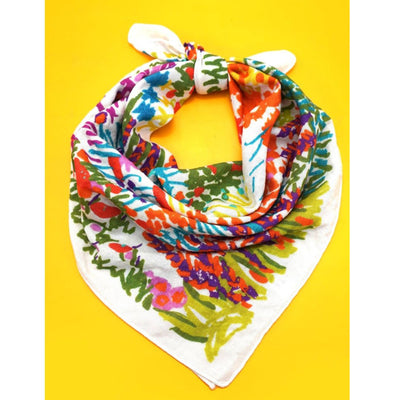 The JOSSLYN by wall to wall COTTON FLORAL PRINT BANDANA SCARF, crafted from silky-feel cotton, features vibrant red, green, orange, and purple florals on white with a knotted top and is displayed on a bright yellow background.