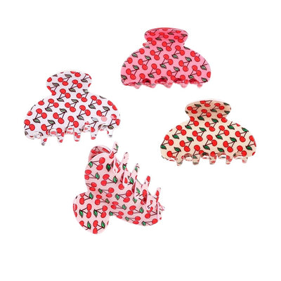 The image showcases four Cherries Hair Claw Clips by Judson & Company, each about 3 long. They feature a cherry pattern on backgrounds of red, pink, white, and light cream, with slight variations in size and shape.