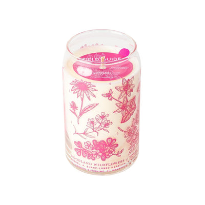 The Woodland Wildflowers Soy Candle from Good & Well Supply Co.s Forest Floor Collection features a hand-poured design in a glass jar with pink floral and butterfly illustrations. This pink wax candle, with two wicks, enriches any space with its natural charm.